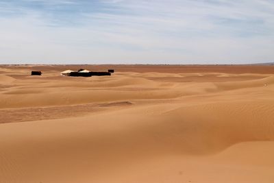 Mid distance view of tents in sahara desert against sky