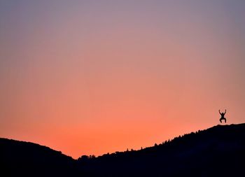 Scenic view of silhouette mountains against clear sky during sunset