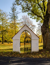 Built structure by trees against sky during autumn