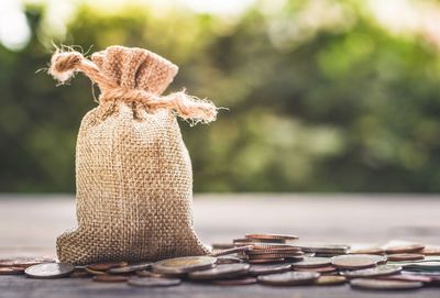 Tied sack and coins on table