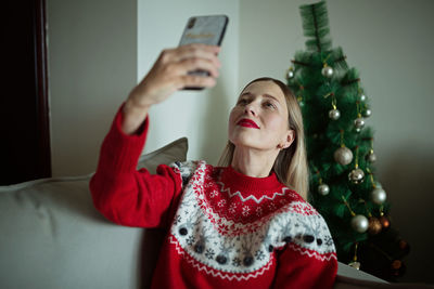 Young woman using mobile phone at home