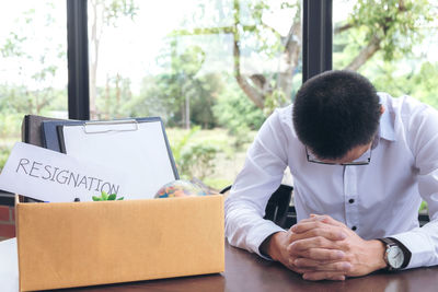 Businessman sitting by box at table