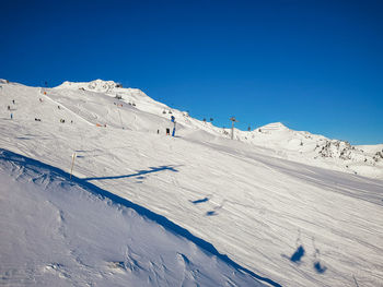 Scenic view of snowcapped mountains against clear blue sky