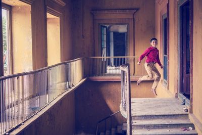 Portrait of teenage boy jumping in abandoned building