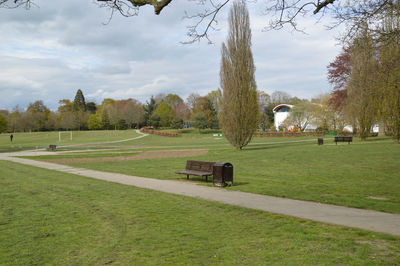 Trees on field in park against sky