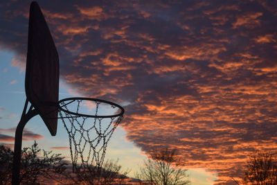 Low angle view of basketball hoop against sky during sunset