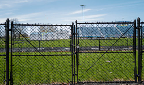 Chainlink fence on field against sky