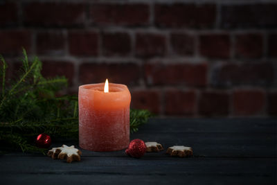 Close-up of illuminated candle on table