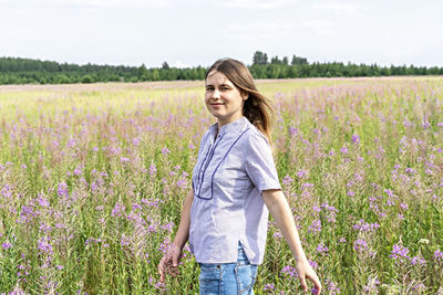 Beautiful young woman standing in field