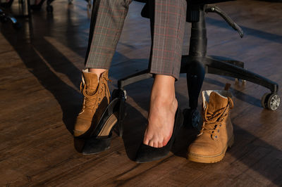 Low section of person wearing shoes on hardwood floor