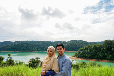 Portrait of couple kissing against sky