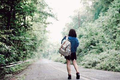 Rear view of woman walking on road