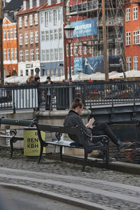 Man sitting on bench in city