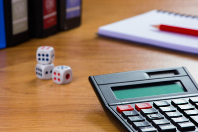 Dice, calculator and book on the table