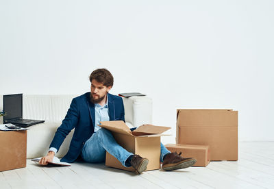 Young man sitting in box