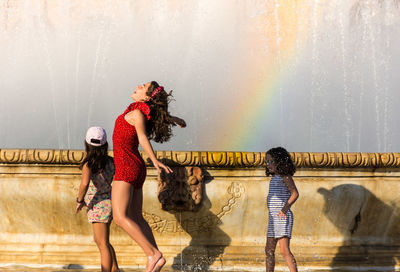 Full length of woman with people in water