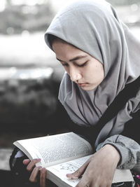 Midsection of young woman reading book