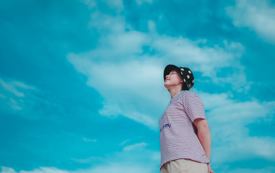 Low angle view of woman standing against sky