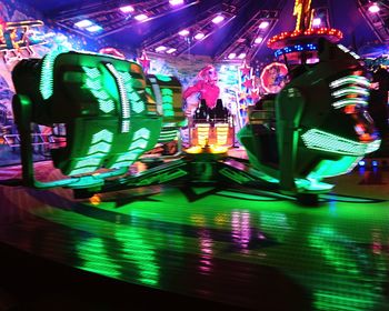 Illuminated carousel in amusement park at night