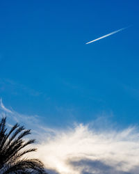 Low angle view of vapor trail against blue sky