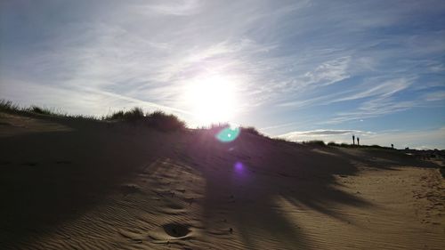 Scenic view of sand dunes against sky