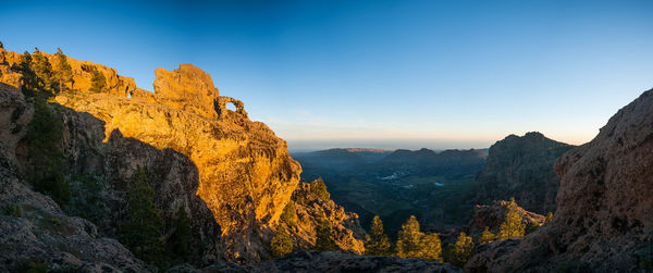 Rock formations on mountain against blue sky