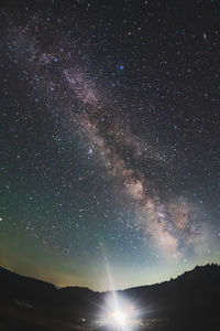 Low angle view of silhouette trees against sky at night