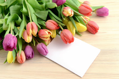 Close-up of tulips and greeting card on table