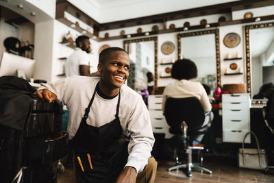 Smiling male hairdresser looking away in barber shop