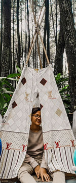 Portrait of girl relaxing on tree trunk in forest