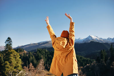 Rear view of woman standing against mountain