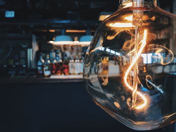 Close-up of illuminated light bulb in cafe