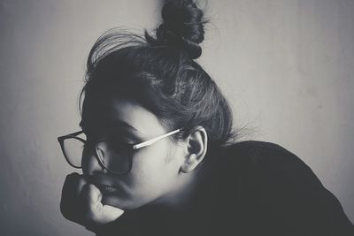 Close-up of girl wearing eyeglasses against white background