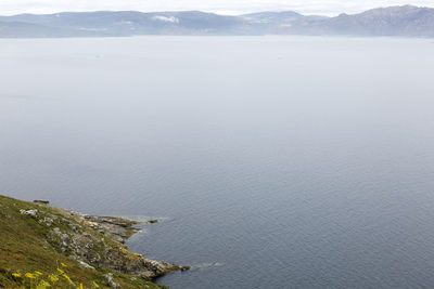 Scenic view of sea and mountains against sky