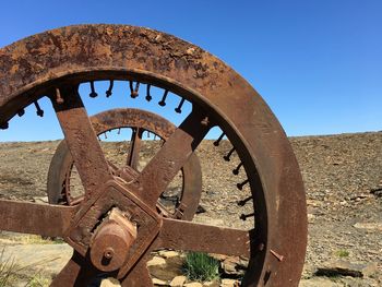 Old rusty wheel against clear blue sky