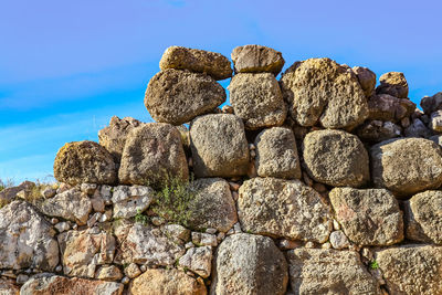 Low angle view of stack on rocks against blue sky