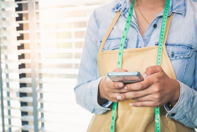 Midsection of woman using mobile phone