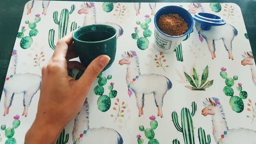 Hand holding coffee cup on table