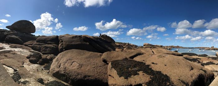 Rock formations on beach against sky