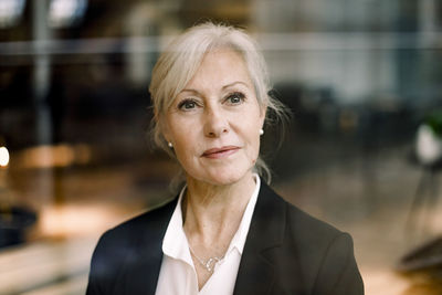 Thoughtful confident mature businesswoman looking away at office