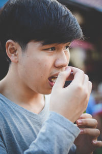 Close-up of young man eating food outdoors