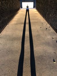 Shadow of person standing on footpath