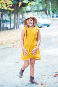 Cheerful girl looking away while walking on road