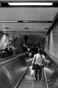 Rear view of people on escalator at subway station