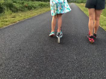 Low section of women walking on road