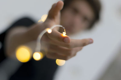 Close-up of hand holding lit candle