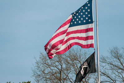 Low angle view of flag against blue sky