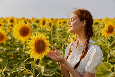 Portrait of woman holding sunflower