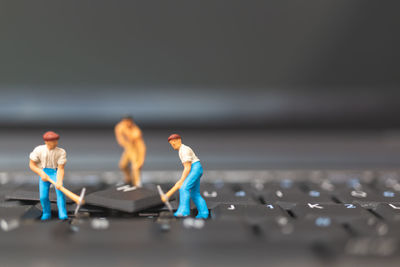 Close-up of figurines on computer keyboard