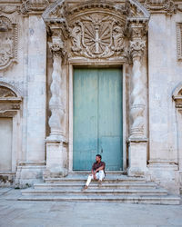 Full length of woman on closed door of building